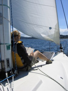 Person leaning against the mast on a sailboat - Sailing Lessons - Bareboat Charter