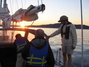 Sailors on a boat with a sunset - Basic Coastal Cruising Sailing Lesson