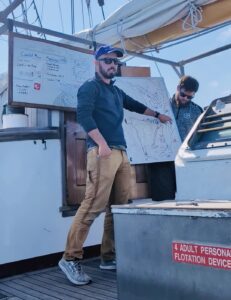 Captain Ted Moskal points to a whiteboard while teaching sailing