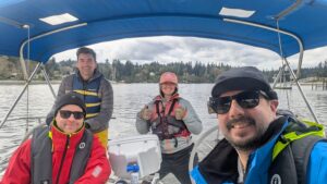 Four people are on a sailboat smiling